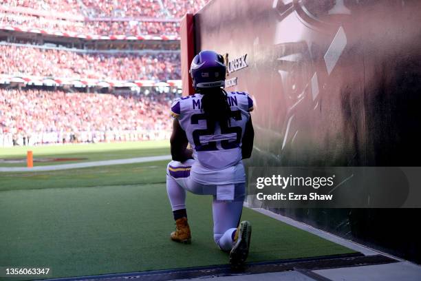 Alexander Mattison of the Minnesota Vikings kneels during the national anthem in the hallway before the game against the San Francisco 49ers at...