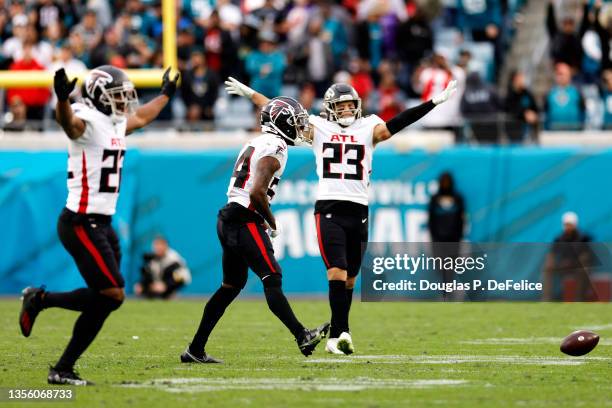 Fabian Moreau, Darren Hall and Erik Harris of the Atlanta Falcons react after making a defensive stop on fourth down against the Jacksonville Jaguars...