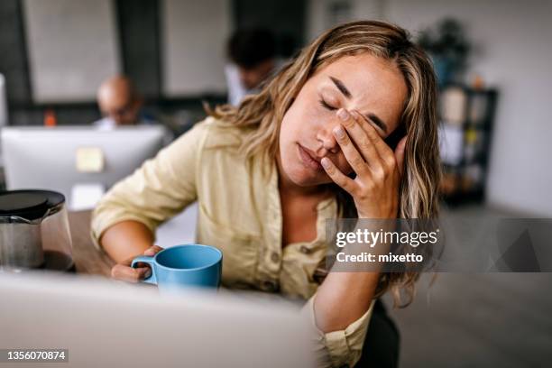 mujer de negocios cansada frotándose los ojos - agotado fotografías e imágenes de stock