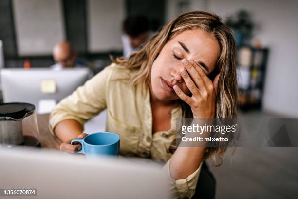 donna d'affari stanca che si strofina gli occhi - mettersi le mani nei capelli foto e immagini stock