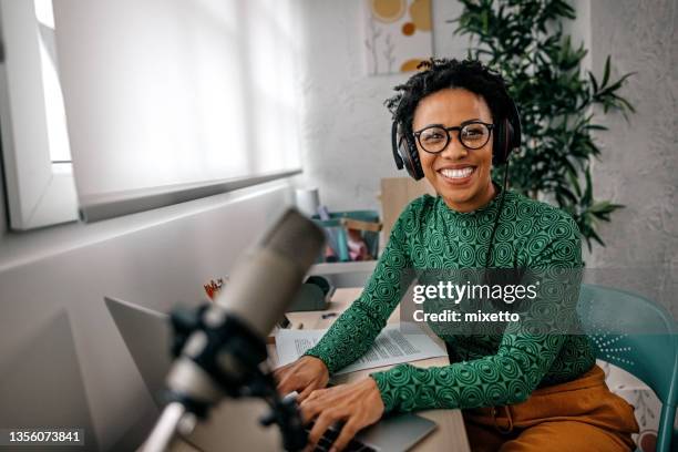 smiling young woman working on laptop - radio host stock pictures, royalty-free photos & images