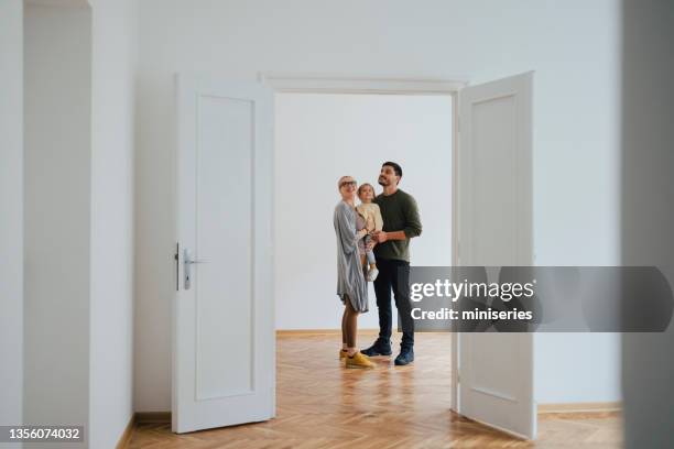 une famille enthousiaste emménage dans une nouvelle maison - space family photos et images de collection