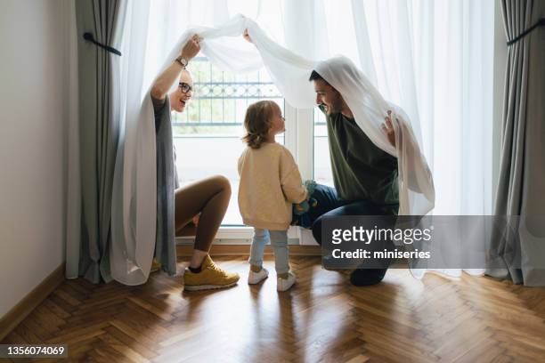 happy family having fun in new home - drapeado stock pictures, royalty-free photos & images