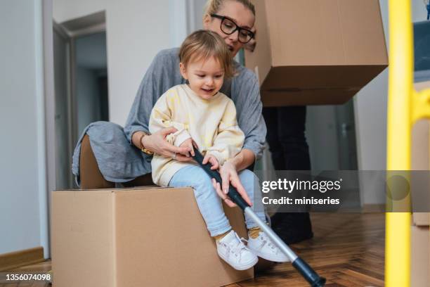 mother and daughter playing hockey on the floor - hockey mom stock pictures, royalty-free photos & images