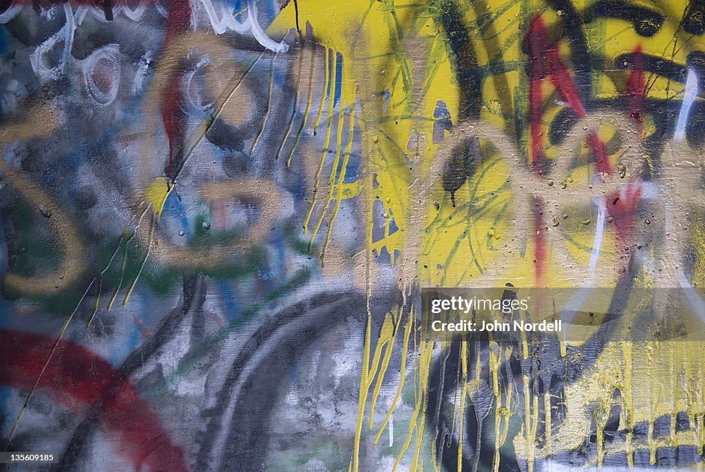 Graffiti on cement wall underneath a bridge