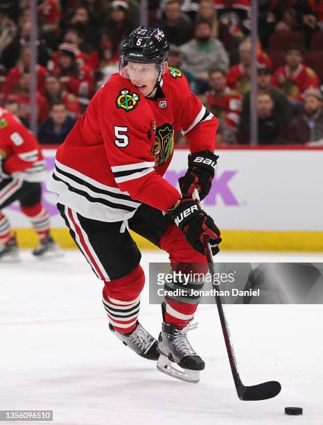 Connor Murphy of the Chicago Blackhawks turns with the puck against the San Jose Sharks at the United Center on November 28, 2021 in Chicago,...