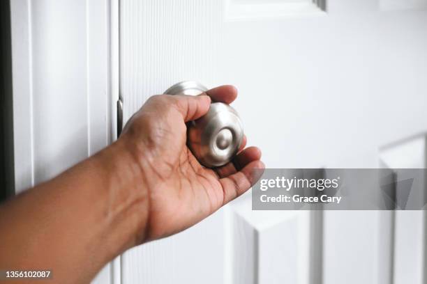 woman with hand on doorknob - close door stock pictures, royalty-free photos & images