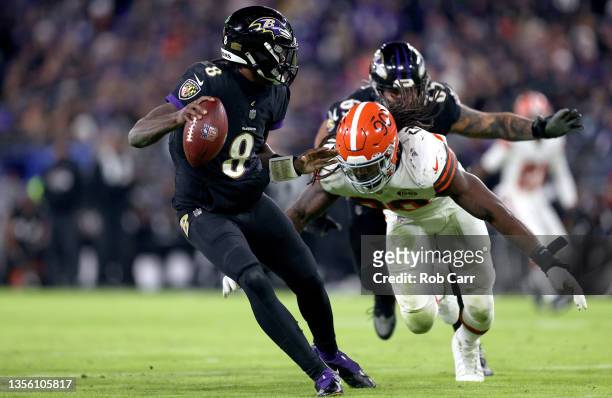 Jadeveon Clowney of the Cleveland Browns pressures Lamar Jackson of the Baltimore Ravens during a game at M&T Bank Stadium on November 28, 2021 in...