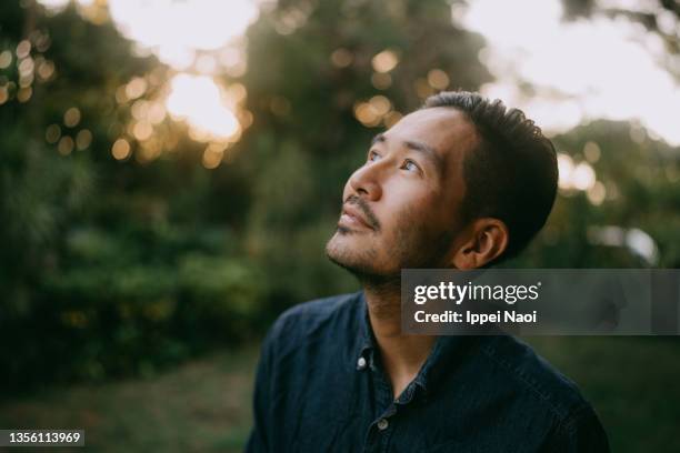 portrait of man contemplating - looking up 個照片及圖片檔