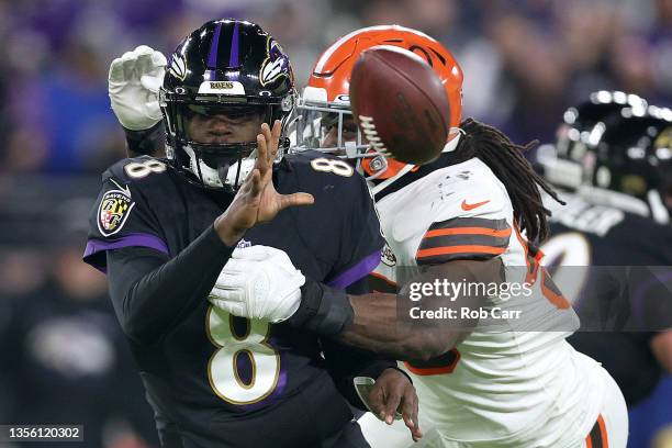 Quarterback Lamar Jackson of the Baltimore Ravens pitches the ball while being hit by defensive end Jadeveon Clowney of the Cleveland Browns at M&T...