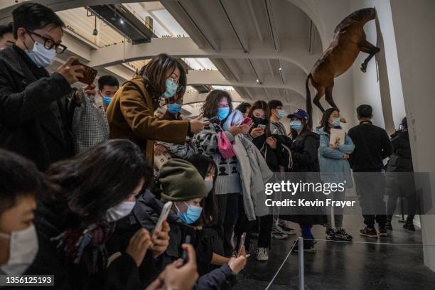 Visitors take pictures of work by Italian artist Maurizio Cattelan that is part of his exhibition "The Last Judgement'' at the UCCA Center for...