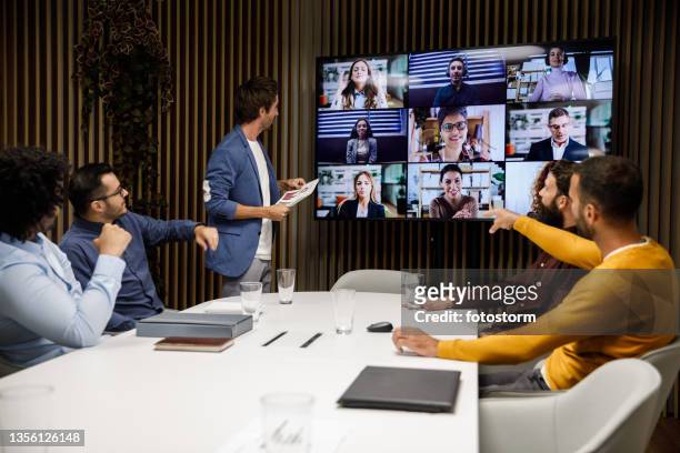 group of businessmen having a virtual business meeting with their colleagues - board room stock pictures, royalty-free photos & images