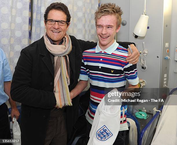 In this handout image provided by the FA, England manager Fabio Capello poses with patient Alfie Knight on a visit to Great Ormond Street Hospital on...