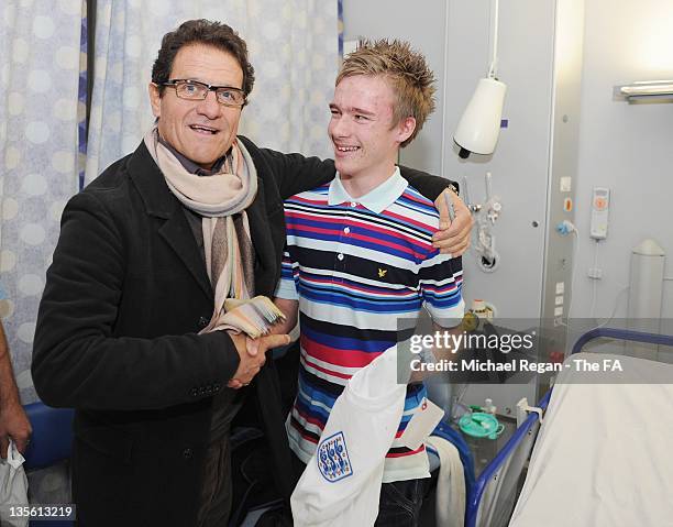 In this handout image provided by the FA, England manager Fabio Capello poses with patient Alfie Knight on a visit to Great Ormond Street Hospital on...