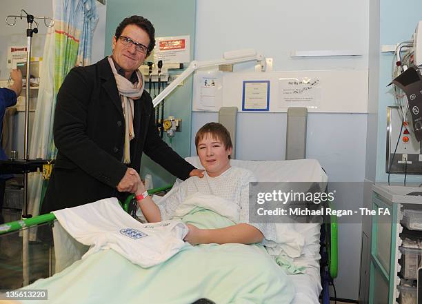 In this handout image provided by the FA, Manager Fabio Capello of England poses with patient George Medcalf on a visit to Great Ormond Street...