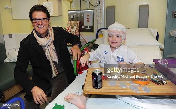 In this handout image provided by the FA, Manager Fabio Capello of England visits patient Tiarnan Smith on a visit to Great Ormond Street Hospital on...