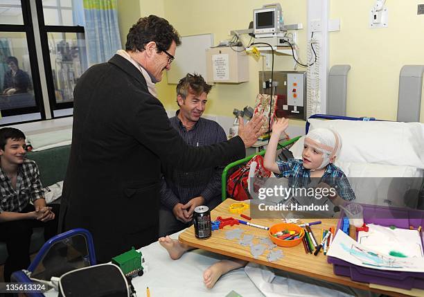 In this handout image provided by the FA, Manager Fabio Capello of England greets patient Tiarnan Smith on a visit to Great Ormond Street Hospital on...