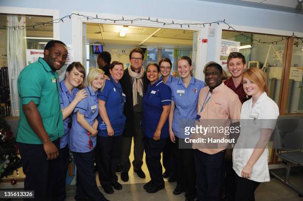 In this handout image provided by the FA, England manager Fabio Capello pose with staff on the Parrott Ward on a visit to Great Ormond Street...