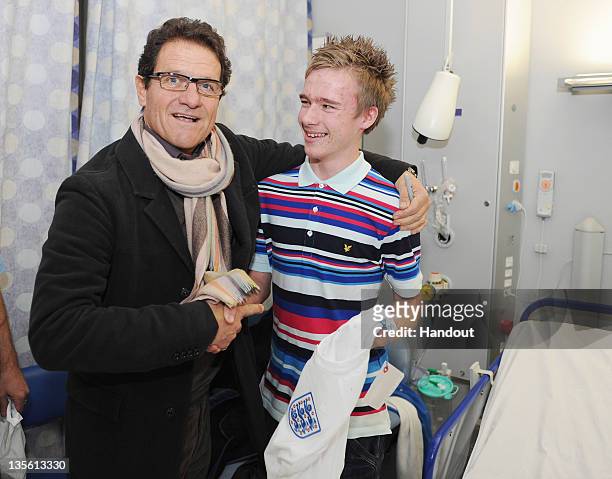 In this handout image provided by the FA, England manager Fabio Capello poses with patient Alfie Knight on a visit to Great Ormond Street Hospital on...