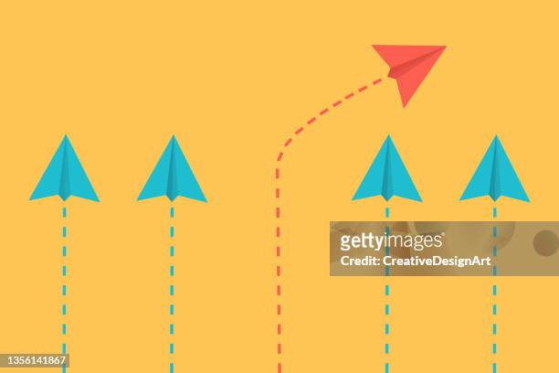 standing out from the crowd, think differently, individuality and leadership concept with paper airplanes. individual red paper plane flying in different direction. - paper aeroplane stock illustrations