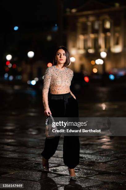 Alexandra Pereira wears a beige transparent tulle with embroidered silver rhinestones long sleeves body from Miu Miu, black high waist puffy / baggy...