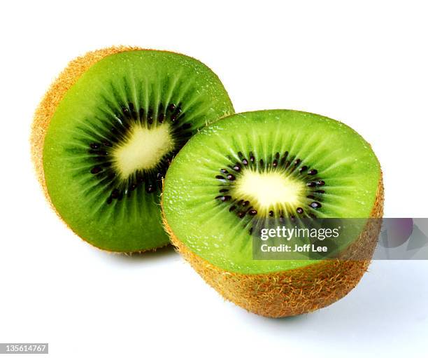 kiwi fruit cut in half - tropische frucht stock-fotos und bilder