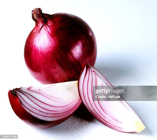 red onion with two cut sections - red onion stockfoto's en -beelden