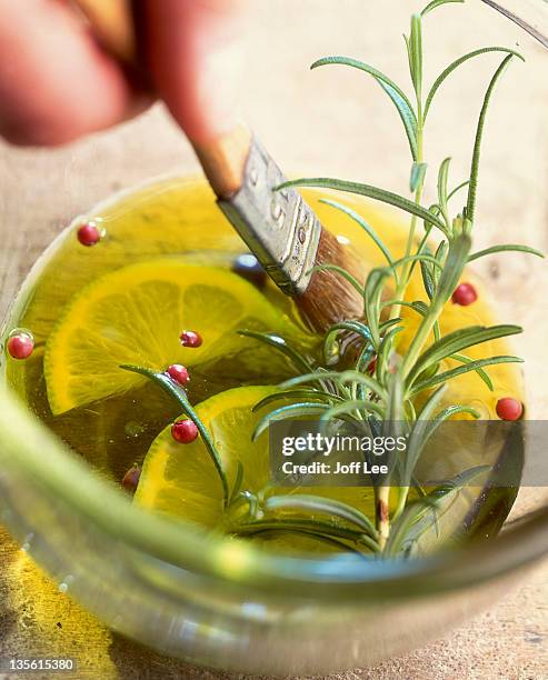 dipping brush into lemon oil dressing - vinaigrette dressing photos et images de collection