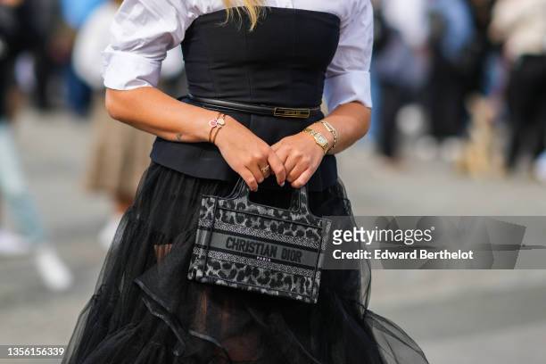 Valentina Ferragni wears a white shirt, a black shoulder-off t-shirt, a black shiny leather Christian Dior buckle belt, a black tulle large midi...