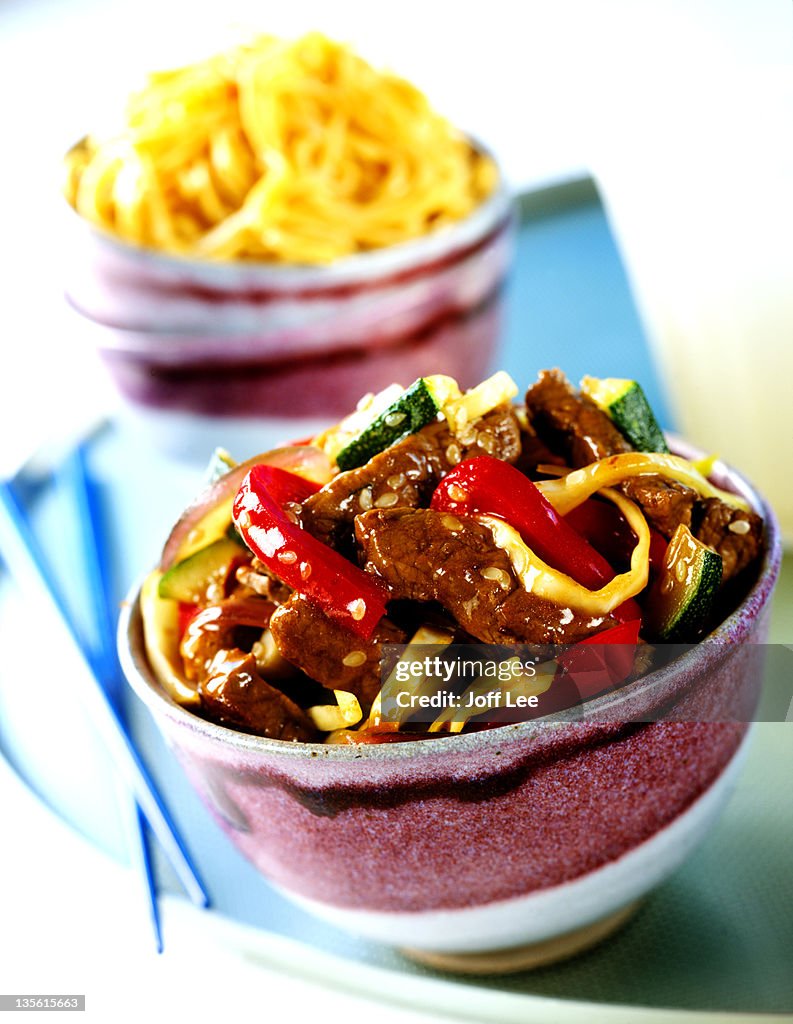 Beef & noodle stir-fry in bowl with chopsticks