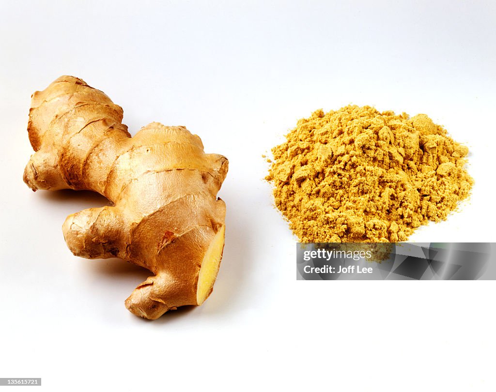 Fresh root ginger with pile of ginger powder
