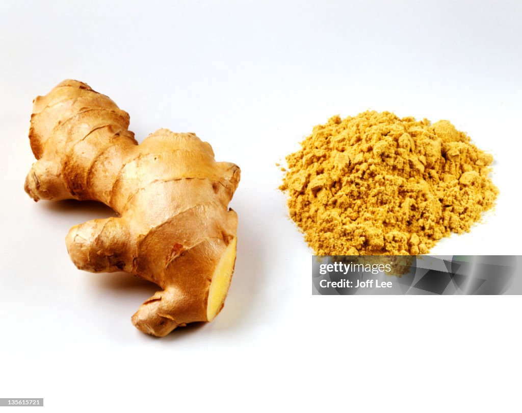 Fresh root ginger with pile of ginger powder