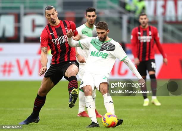 Domenico Berardi of US Sassuolo is challenged by Zlatan Ibrahimovic of AC Milan during the Serie A match between AC Milan and US Sassuolo at Stadio...
