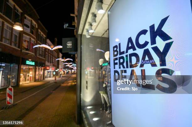 black friday deals sale sign in a shop window in a shopping street - friday stock pictures, royalty-free photos & images