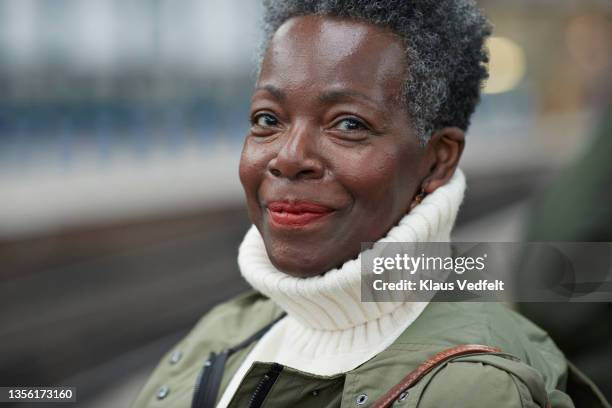 smiling elderly woman at railroad station - winter clothing stock pictures, royalty-free photos & images