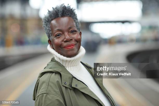 senior woman wearing warm clothing at station - focus on foreground stock pictures, royalty-free photos & images