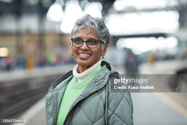 elderly woman looking away at railroad station - east sussex stock-fotos und bilder
