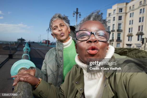 female friends standing in footpath - puckering stock pictures, royalty-free photos & images