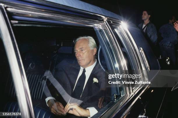 Canadian actor Christopher Plummer sitting in hthe backseat of a parked car, wearing a black suit and tie, with a boutonniere, location unspecified,...