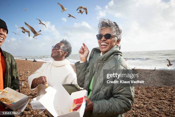 cheerful male and female friends having french fries - grupo de animales fotografías e imágenes de stock
