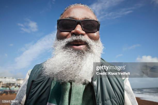 smiling senior man with white beard at beach - disruptagingcollection fotografías e imágenes de stock