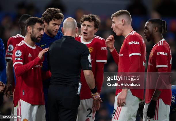 Bruno Fernandes, Victor Lindelöf, Scott McTominay and Aaron Wan-Bissaka of Manchester United confront match referee Anthony Taylor during the Premier...