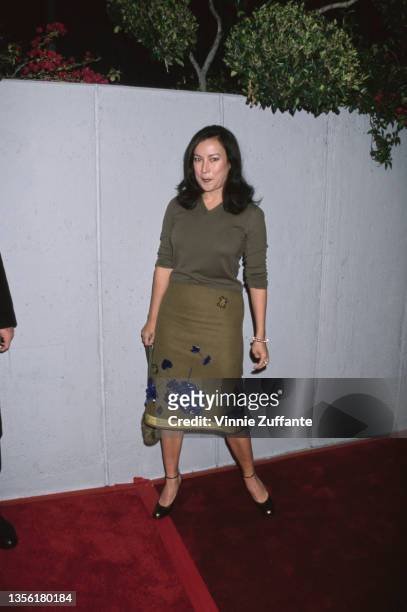 American-Canadian actress Jennifer Tilly, wearing an olive green top and a green skirt with yellow trim and blue detail, attends the Hollywood...