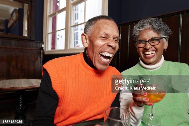 senior couple having cocktails in restaurant - old couple restaurant stock-fotos und bilder