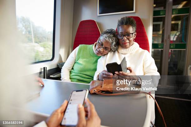 senior woman using mobile phone in train - lgbt mobile foto e immagini stock