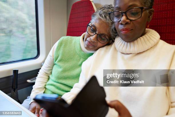 senior passenger using mobile phone in train - tired couple stock pictures, royalty-free photos & images