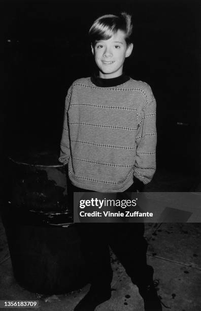 American child actor Danny Pintauro, wearing a crew neck sweater, his hands in the pockets of his black trousers. In Los Angeles, California, circa...