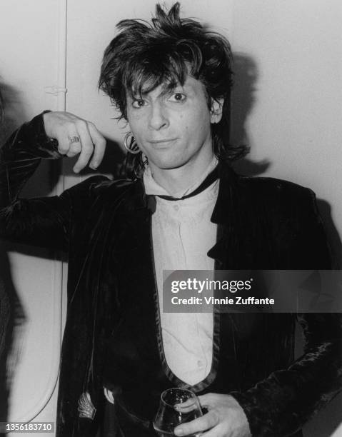 American guitarist, singer and songwriter Johnny Thunders holding a drinking glass at the Limelight in New York City, New York, circa 1985.