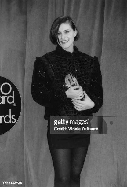 British singer and songwriter Lisa Stansfield, wearing a black jacket and black miniskirt, with her 'Best Newcomer' award in the press room of the...