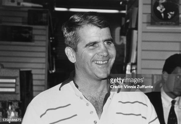 American author and retired US Marine Corps lieutenant colonel Oliver North, wearing a horizontally striped shirt, smiles during an in-store...
